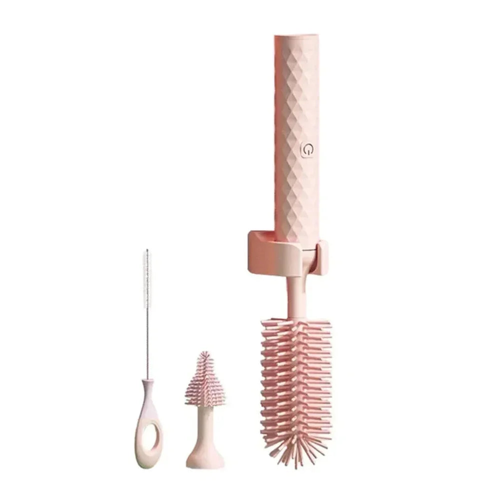 Brosse électrique pour biberons et bouteilles en silicone rose avec tête principale, embout interchangeable et goupillon fin.