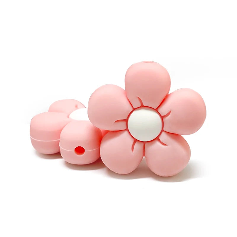 Perle en silicone en forme de fleur rose pastel avec centre blanc, pour création d’attache-tétine personnalisée.