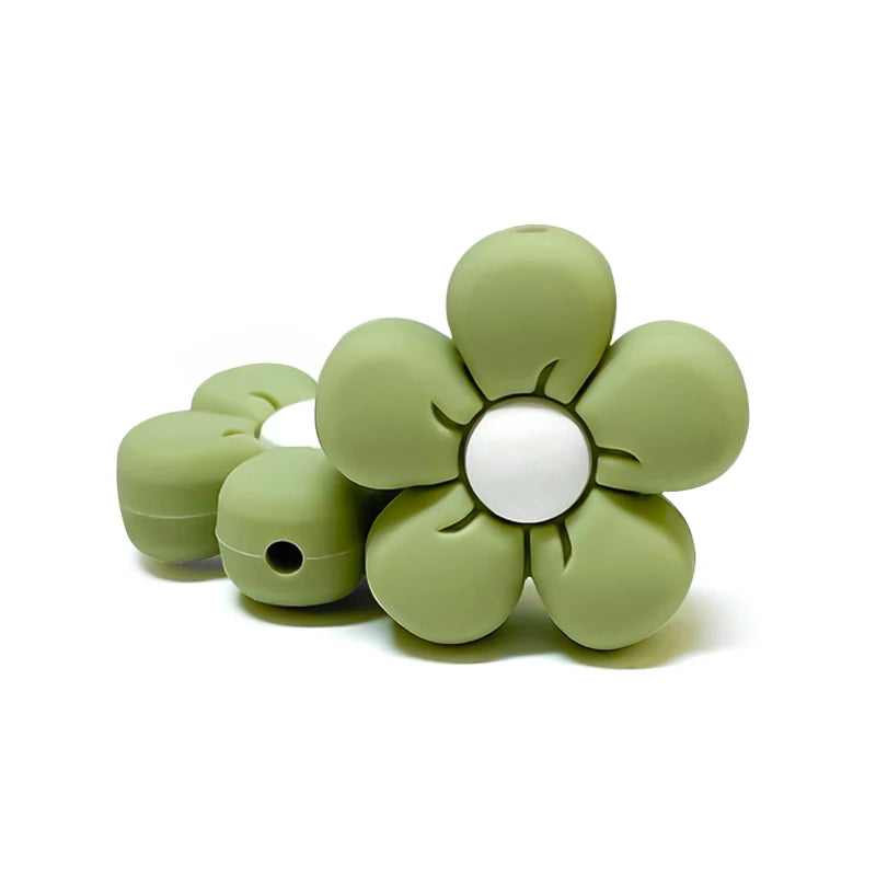 Perle en silicone en forme de fleur vert sauge avec centre blanc, pour création d’attache-tétine personnalisée.