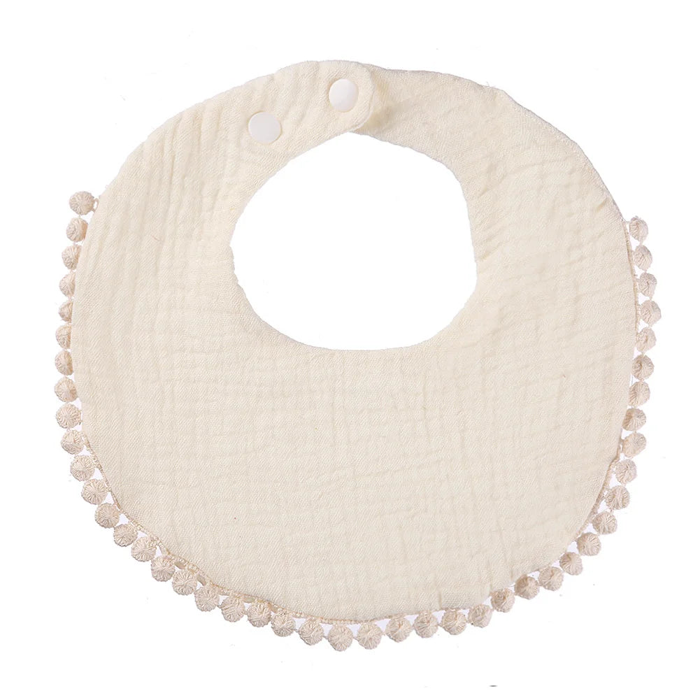 Bavoir bébé en coton mousseline blanc cassé avec bordure pompons et fermeture par boutons-pression