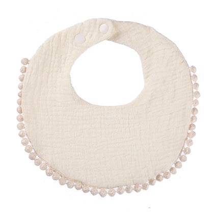 Bavoir bébé en coton mousseline blanc cassé avec bordure pompons et fermeture par boutons-pression