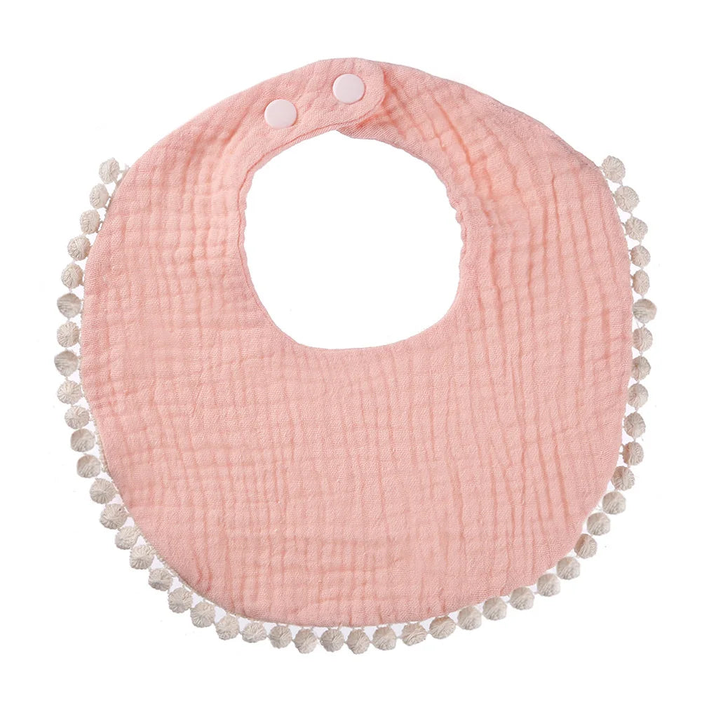 Bavoir bébé en coton mousseline rose pastel avec bordure pompons et fermeture par boutons-pression