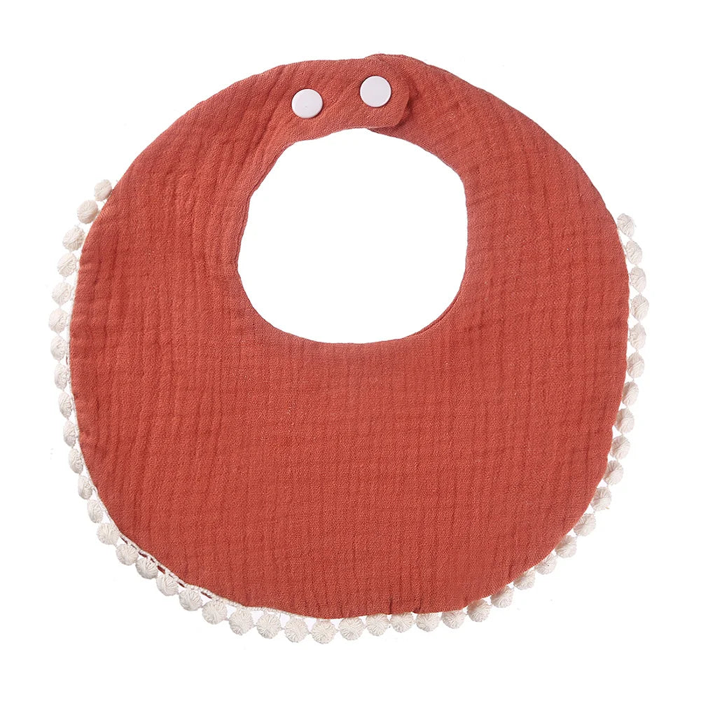 Bavoir bébé en coton mousseline rouge rouille avec bordure pompons et fermeture par boutons-pression