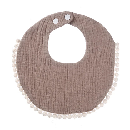 Bavoir bébé en coton mousseline taupe avec bordure pompons et fermeture par boutons-pression