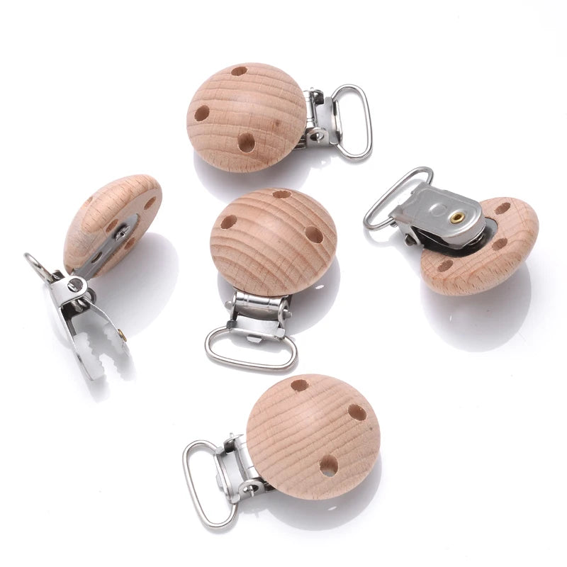 Clips attache-tétine bébé en bois de hêtre naturel percés avec pince en métal, vues sous différents angles pour création de chaînes de tétine DIY