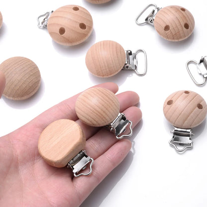Clips attache-tétine bébé en bois de hêtre naturel avec pince en métal présentés dans une main pour montrer la taille réelle, accessoires DIY