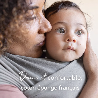 Bébé porté contre son parent en écharpe de portage en coton doux et confortable, respectueuse de la peau sensible