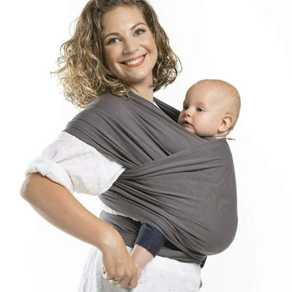 Maman portant son bébé en écharpe de portage en coton extensible gris, assurant maintien ergonomique et confort au quotidien