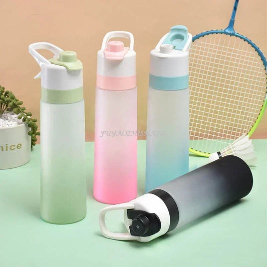 Gourdes spray sport 700 ml sans BPA en plusieurs couleurs, posées sur une surface avec accessoires de sport, idéales pour le fitness, le voyage et les activités outdoor.