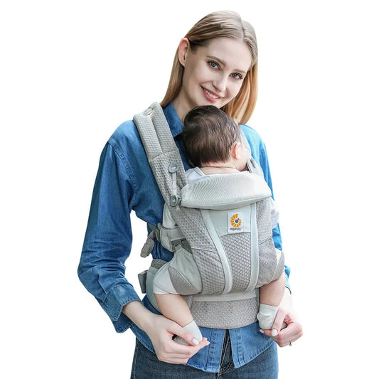 Maman portant un bébé dans un porte-bébé Ergobaby Omni Breeze en maille respirante, portage ventral ergonomique avec soutien lombaire et bretelles rembourrées